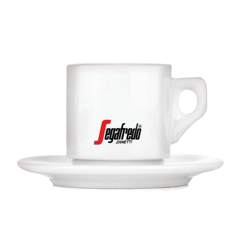 The Segafredo Cup & Saucer Set by Segafredo Zanetti features a white ceramic espresso cup and saucer with the brand's logo, elegantly displayed against a plain background.