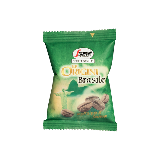 A green Segafredo Zanetti® Coffee packet labeled "Le Origini Brasile" with an image of coffee beans and a statue, featuring text "Morbido & Soave." The Brazilian Single Origin Espresso Single-Serve Cartridges highlight the rich flavors from the Nossa Senhora da Guia plantation.